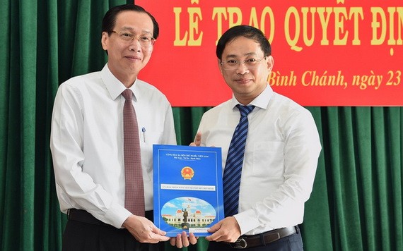 新任平政縣人委會主席陶嘉旺（右）從市人委會常務副主席黎清廉手中接過人事委任《決定》。（圖源：越勇）