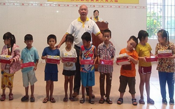芽莊廣東會館理事長鄭成龍給小朋友派發月餅。