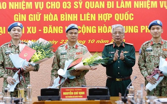 國防部副部長阮志詠上將（右二）向前往南蘇丹與中非共和國參與聯合國維和行動的軍官頒授國家主席《決定》並贈送鮮花祝賀。（圖源：VGP）