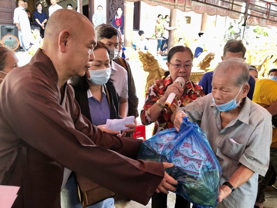 第八郡紅十字輔助會會長釋慧功上座向貧困長者贈送禮物。