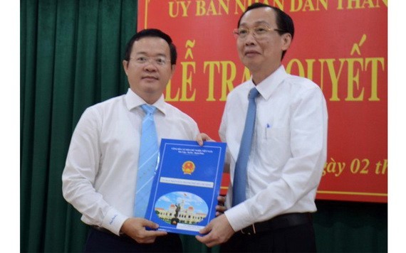 新任平盛郡人委會主席丁克輝（左）從市人委會常務副主席黎清廉手中接過人事委任《決定》。（圖源：蔡芳）