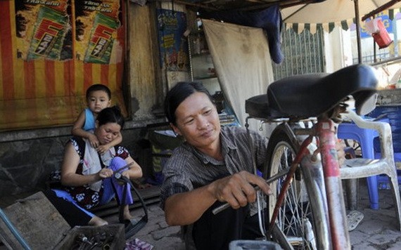 何文鴻正在修車謀生。