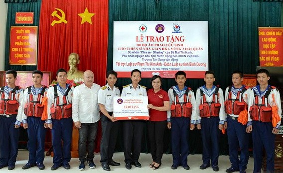 原國家主席張晉創夫人梅氏幸（右五）向DK1瞭望台營的幹部戰士們贈送救生衣。（圖源：春強）