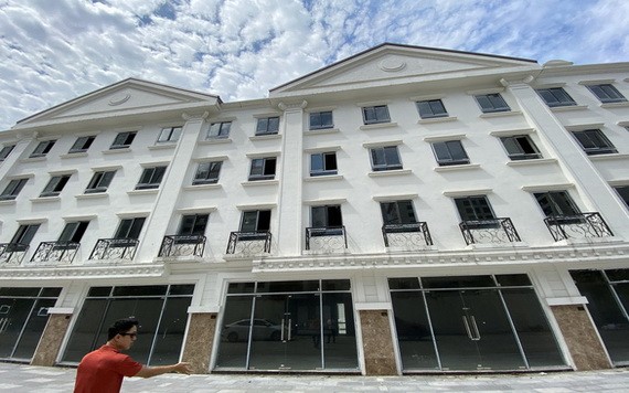 阮英俊站在面積少了26平方米的住房前面。