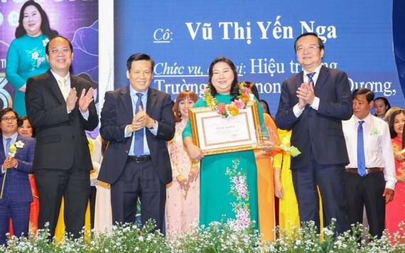 市委副書記阮胡海(左一)、《西貢解放報》執行副總編輯阮玉英(左二)與市教育與培訓廳長黎鴻山(右)給模範教師頒獎。（圖源：黃雄）