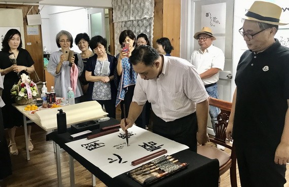 韓國書法愛好者觀賞林漢城即席揮毫。