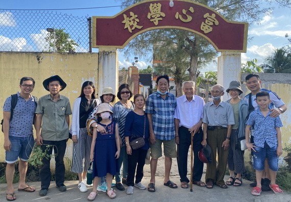 陸進義老師與鄉親和學生們在母校前合影。