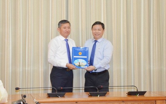 新任市教育與培訓廳副廳長楊智勇（左）從市人委會副主席楊英德手中接過人事委任《決定》。（圖源：孟和）