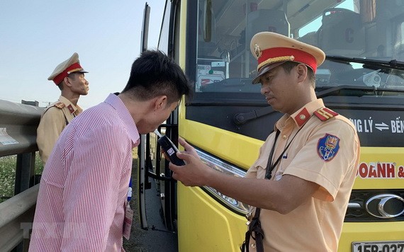 交警在給一名客車司機進行呼氣式酒精測試。（圖源：越通社）