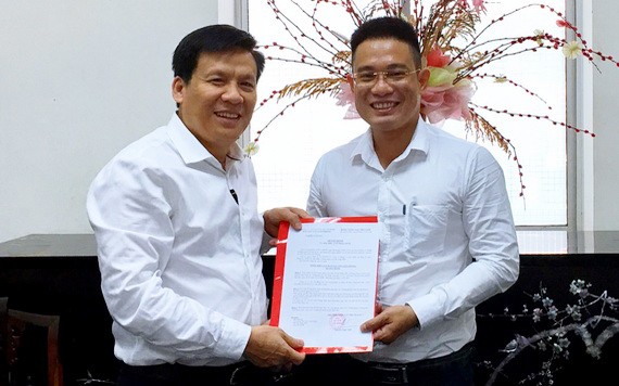 《西貢解放報》執行副總編輯阮玉英(左)向文忠孝同志頒授任命書。