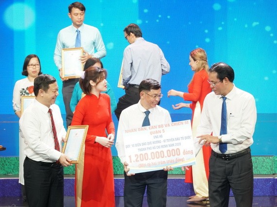 第五郡越南祖國陣線委員會副主席陳南德(中)代表郡移交善款。