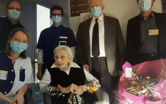 因為疫情的關係，大家在客廳裏都帶著口罩，給老壽星獻了一束鮮花，免了分享蛋糕的節目。（圖源：互聯網）