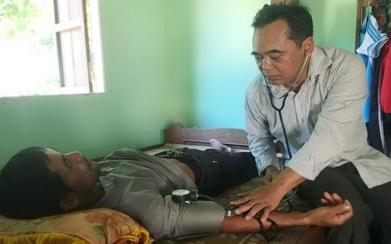 慶永縣縣委書記牟文飛為連創鄉貧民診病。