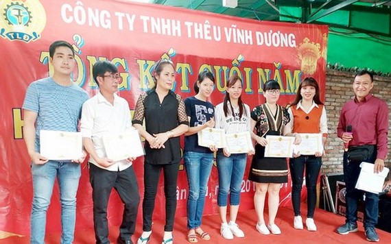 新富郡永揚刺繡有限責任公司黨支書兼工會主席廖玉山（右）向優秀工人 頒發獎狀。