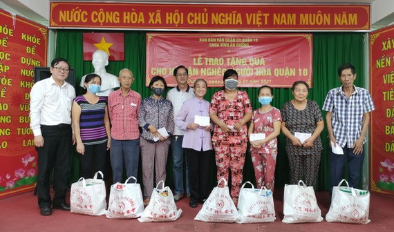 阮北南副書記（左一）與藏霞洞永安堂住持何金蓮（右五）向華人同胞贈送禮物。