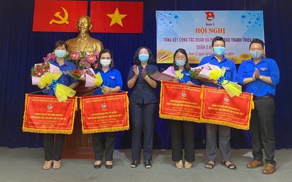 郡人民議會主席黃玉女芳紅(左三)、共青團第五郡郡委書記黎雄勇(右一)向各領先單位贈送錦旗。