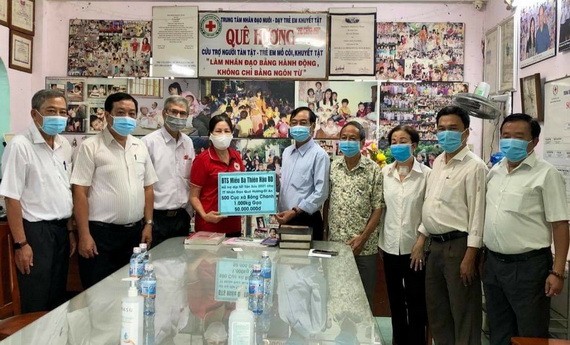 土龍木天后宮副理事長陳永安(右五)向故鄉人道中心代表謝氏梅贈送現金及物資。