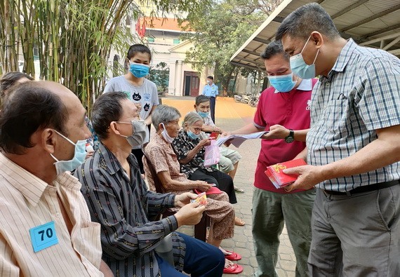 梁栢滔先生向華人貧病者贈送紅包。