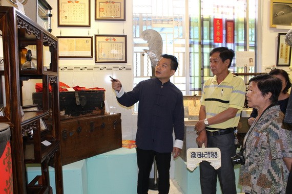 作者向懷舊物品捐贈者介紹陳列空間的西堤華人文物。