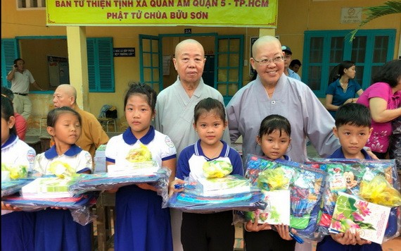 振淨法師（後排右一）向清貧小學生派發禮物。