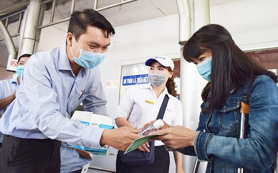 公共交通管理中心副主任黎煌向乘坐巴士的乘客贈送口罩和洗手液。