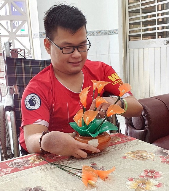 陳文雄拿著他親手做的假花。