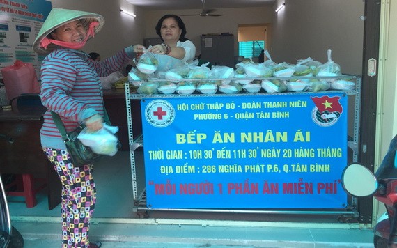 一名女性到“仁愛廚房”俱樂部領取慈善盒飯。