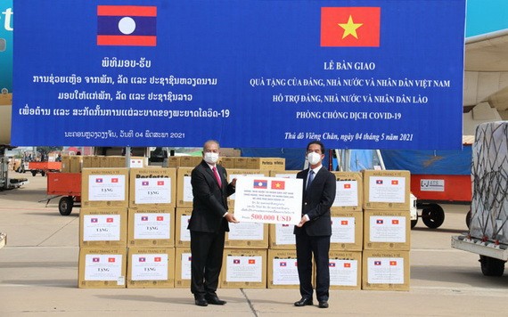 外交部副部長蘇英勇（右）在老撾萬象瓦岱國際機場向老撾副總理吉喬·凱坎匹吞轉交捐贈醫療物資並象徵性為老撾新冠肺炎疫情防控工作捐助50萬美元。（圖源：春山）