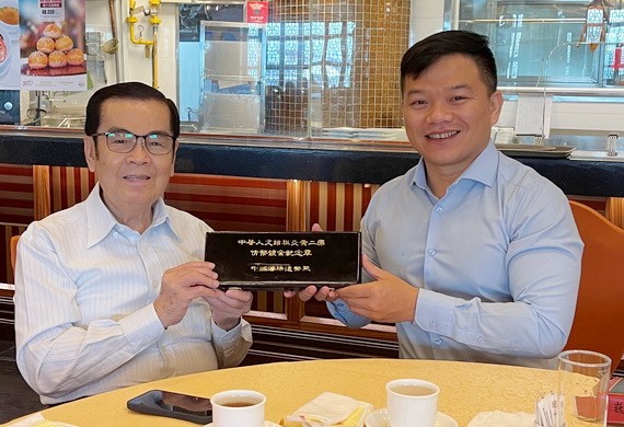 吳清華先生（左）把中國銀行贈予他的紀念幣轉送給“西堤華人文化陳列室”計劃。