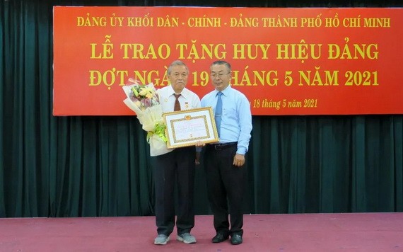 武玉國順同志（右）向阮煌同志（左）頒授55年黨齡紀念章及獎狀。（圖源：秋紅）