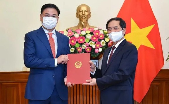 新任外交部副部長范光效（左）從外交部長裴青山手中接過人事委任《決定》。（圖源：國際報）