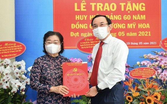 市委書記阮文年（右）向張美華同志（左）頒授60年黨齡紀念章。（圖源：越勇）
