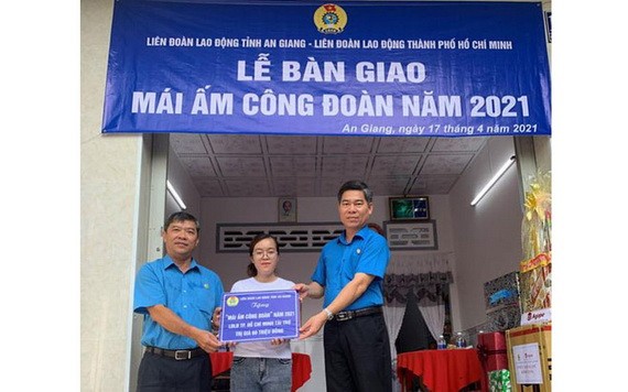市勞動聯團領導（右）與安江省勞動聯團向文氏美家庭贈送“工會溫情屋”。