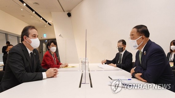 5月25日，在首爾東大門設計廣場舉行的全球綠色目標夥伴2030峰會（P4G）綠色新政特別會議上，南韓副總理兼企劃財政部長官洪楠基（右）和聯合國綠色氣候基金執行董事雅尼克·格萊馬雷克會面。（圖源：韓聯社）