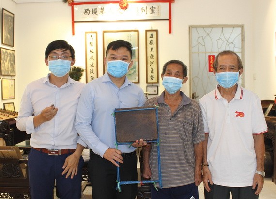 一等抗戰勳章獲得者周純光先生（左三）向陳列室捐贈母親遺物。