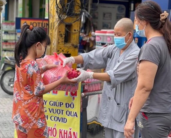 妙法寺住持釋宏心法師向貧困者贈送救濟品。