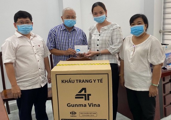 華人企業家呂永雄(左二)向第五郡第四坊領導轉交支持防疫物資。