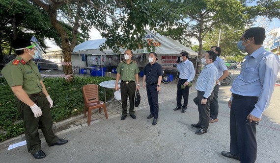 市人委會副主席楊英德（中）同工作團突擊檢查平新郡一隔離區的疫情防控工作。（圖源：文明）