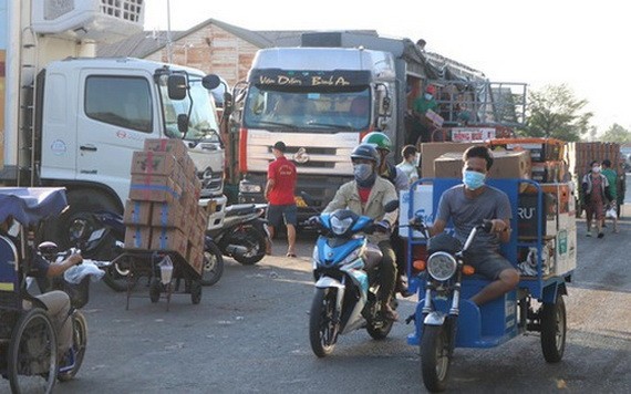人們在守德集散市場附近搬運貨物。（圖源：黃安）