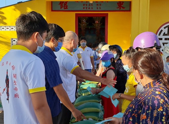 芽莊市廣東會館理事們向貧困者派發濟品。