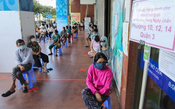 第三郡居民在Co.op Mart超市門外走廊排隊等候購物。（圖源：VnE）