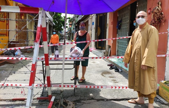 慈福精舍代表釋通振法師向第十坊隔離區貧困居民贈送必需品。