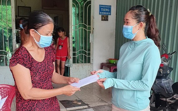 平新郡新造坊人委會副主席阮氏雪絨（右）把補助金交給當地受疫情影響的自由勞工。