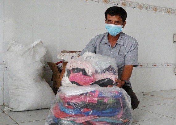 黎老師裹著贈送給清貧學生的書包、背包、衣服。