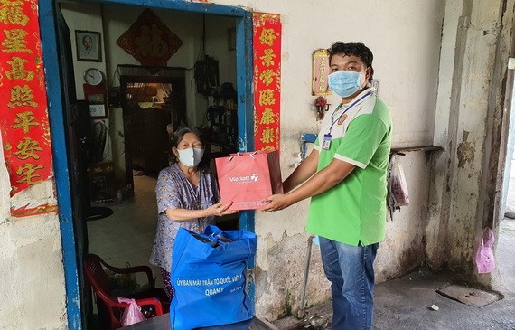 第八郡越南祖國陣線委員會代表贈送禮物給對革命有功華人家庭。