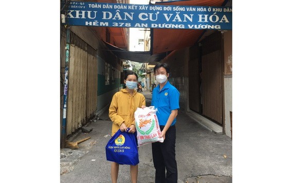 華人幹部文國寶(右)將禮物交給貧困勞動者。