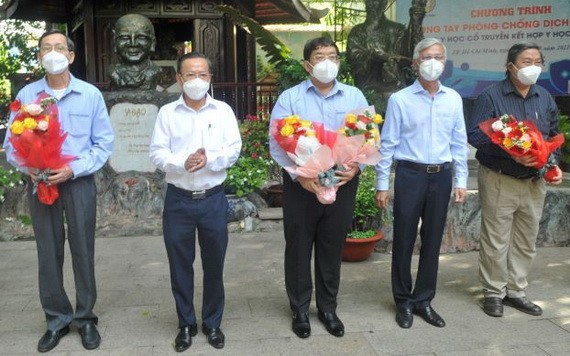 市人委會副主席武文歡(右二)、市委民運處主任阮友協(左二)向各位古傳醫學醫師送花致謝。（圖源: 高昇）