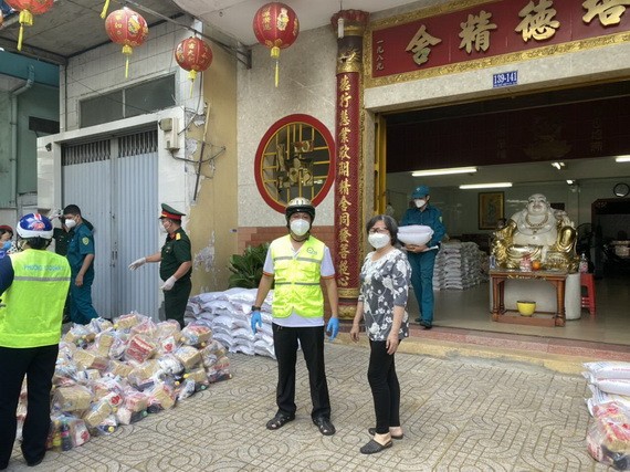 培德精舍副理事長曾碧湄與第十一郡領導給地方受疫情影響生活困難的貧民派發援助品。