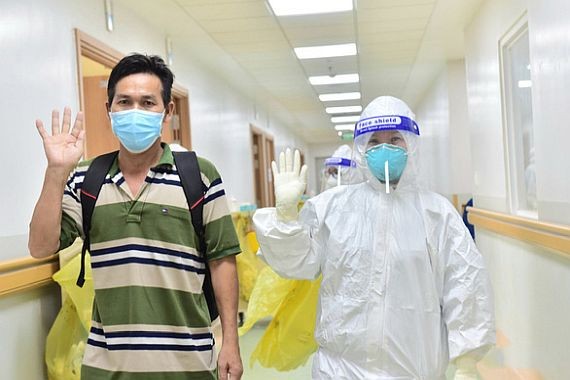 醫護人員送一名新冠肺炎康復者（左）出院。（圖源：緣潘）