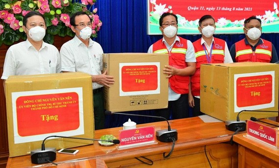 市委書記阮文年（左二）向第十一郡抗疫一線人員贈送禮物。（圖源：紅幸）